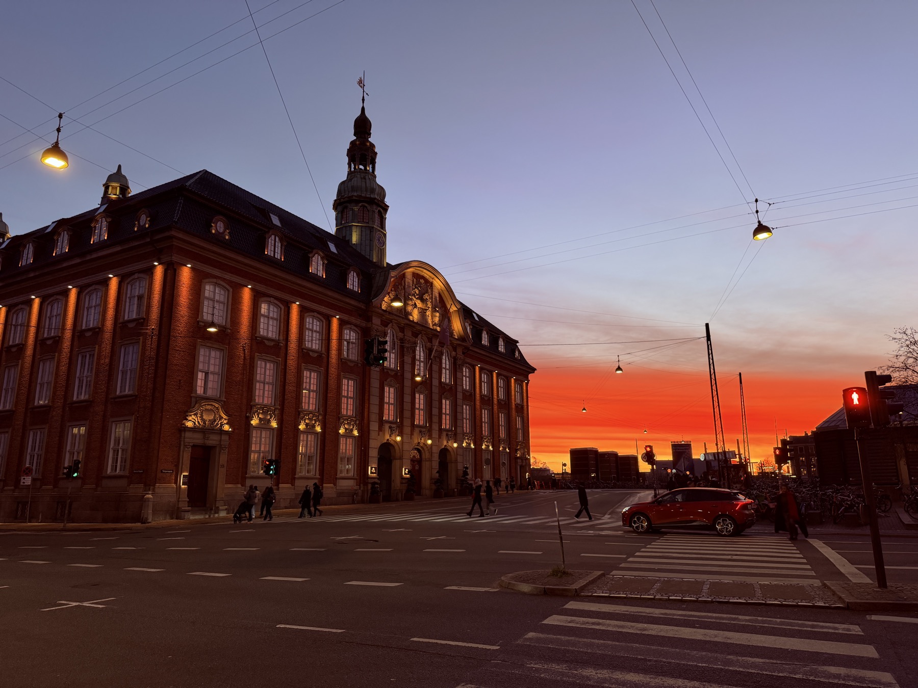 A Danish city street glowing beneath a red-orange sunset