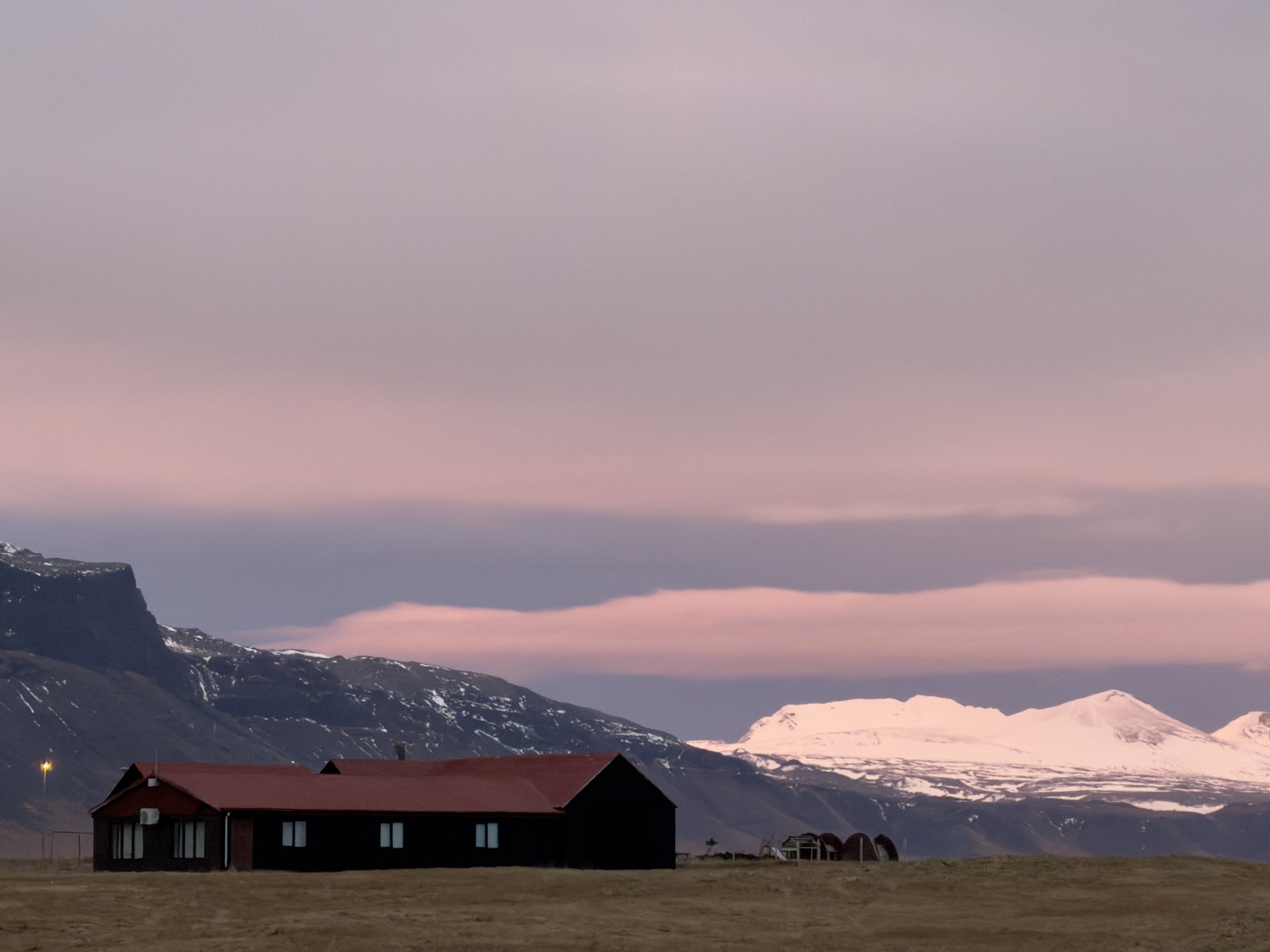 A quiet landscape in western Iceland beneath a pink and purple sunset sky